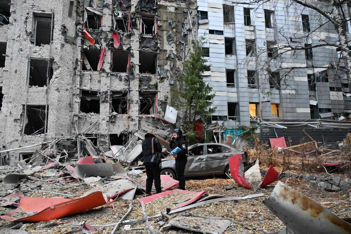 Officials examining buildings destroyed in a Russian air strike on the Ukrainian city of Kharkiv, on Nov 8.