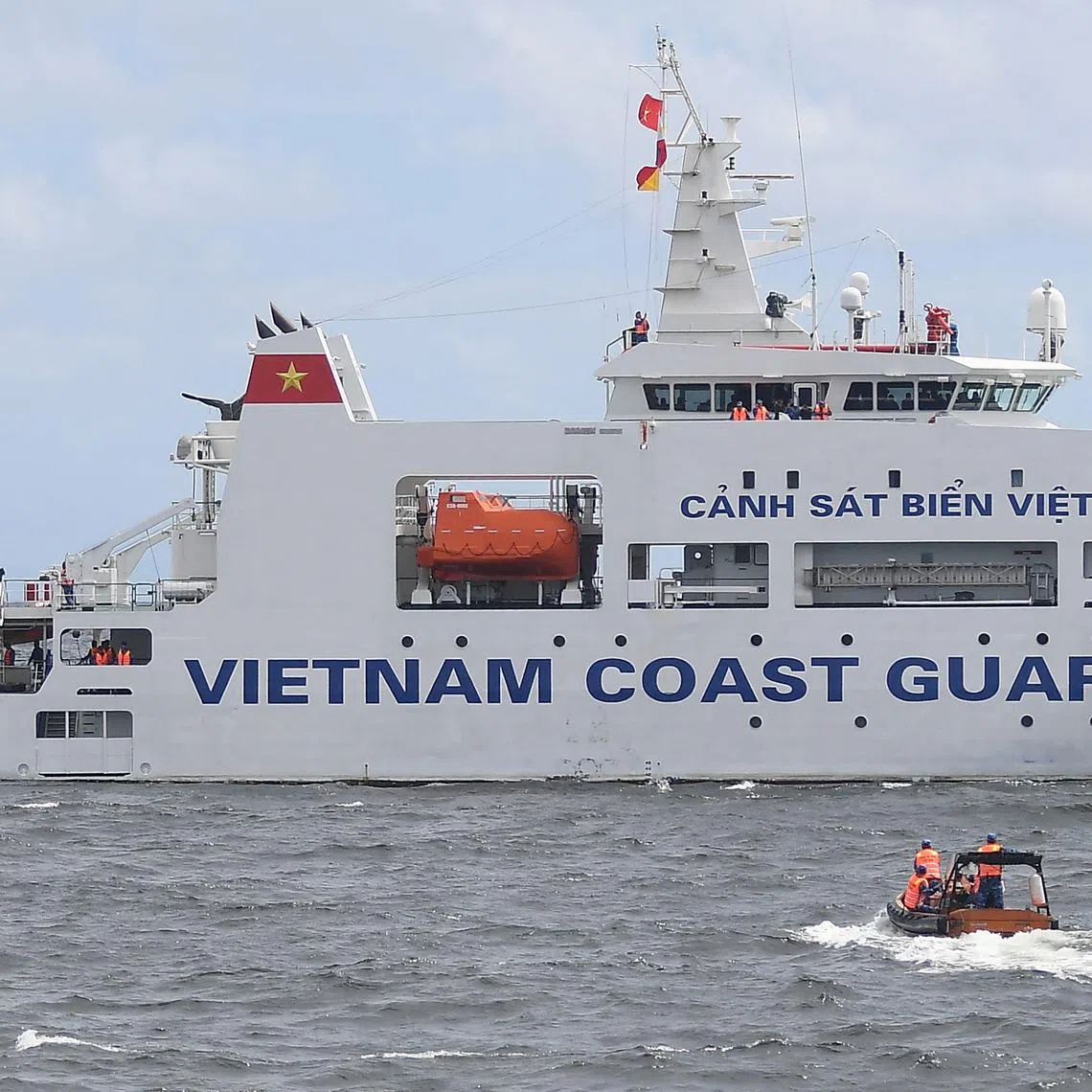Vietnamese Coast Guard personnel sail their rigid hull inflatable boat past their ship during a joint maritime exercise with their Philippine counterparts off Bataan in the disputed South China Sea on August 9, 2024.  (Photo by Ted ALJIBE / AFP)