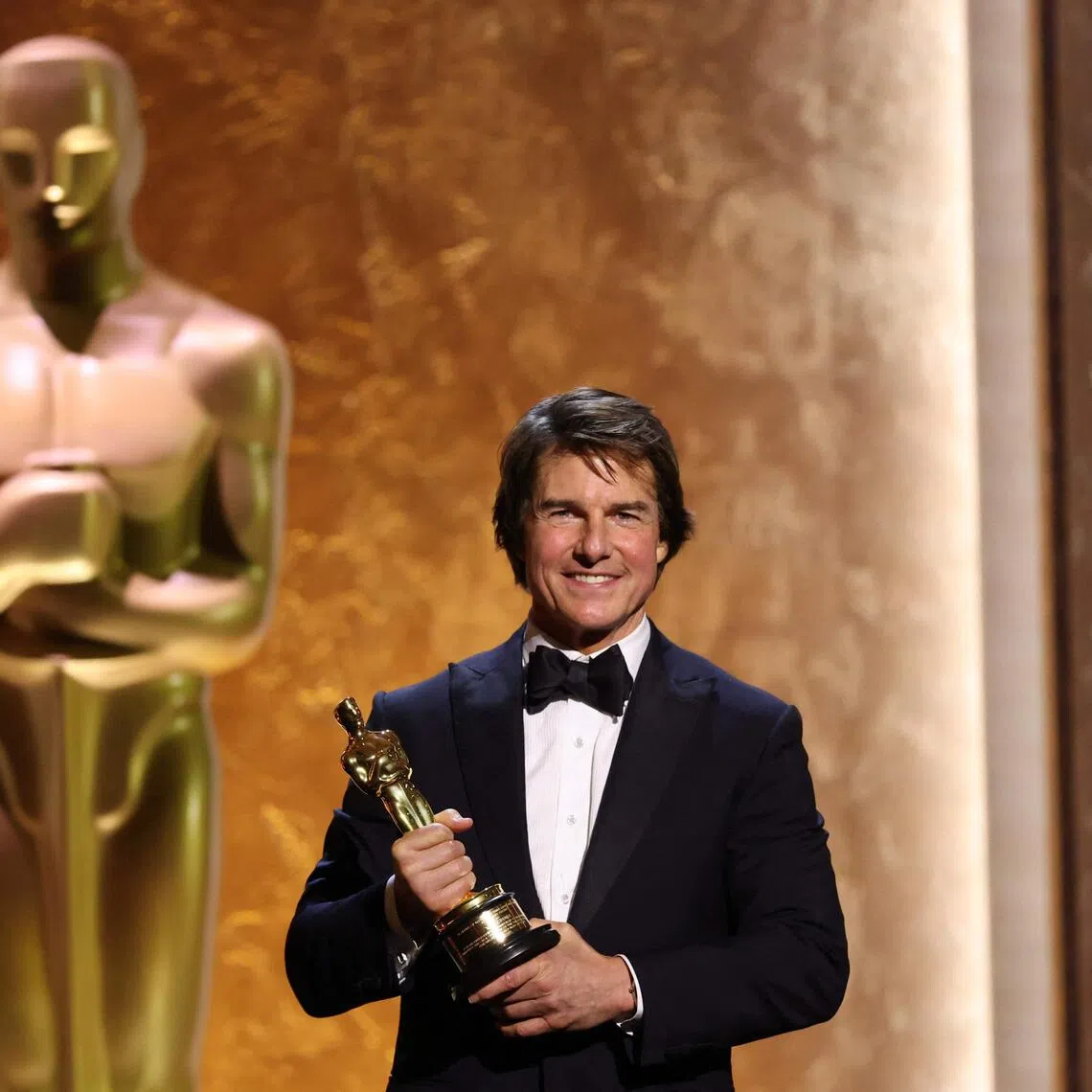 Tom Cruise poses with his Honorary Academy Award on stage during the 16th Governors Awards in Los Angeles on Nov 16.