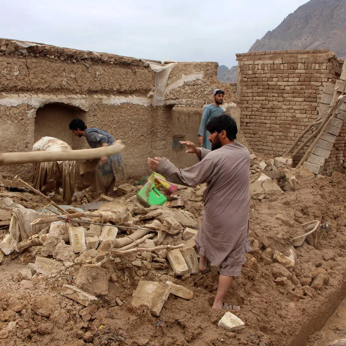 People check the damage on April 2 caused by heavy rains in Kandahar, Afghanistan.