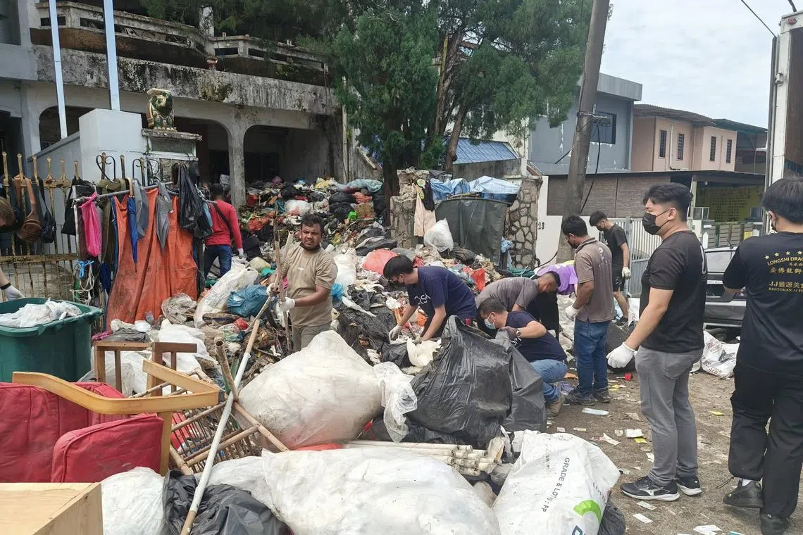 Volunteers removing the massive volume of waste at the man's double-storey house in Taman Sentosa, Johor.