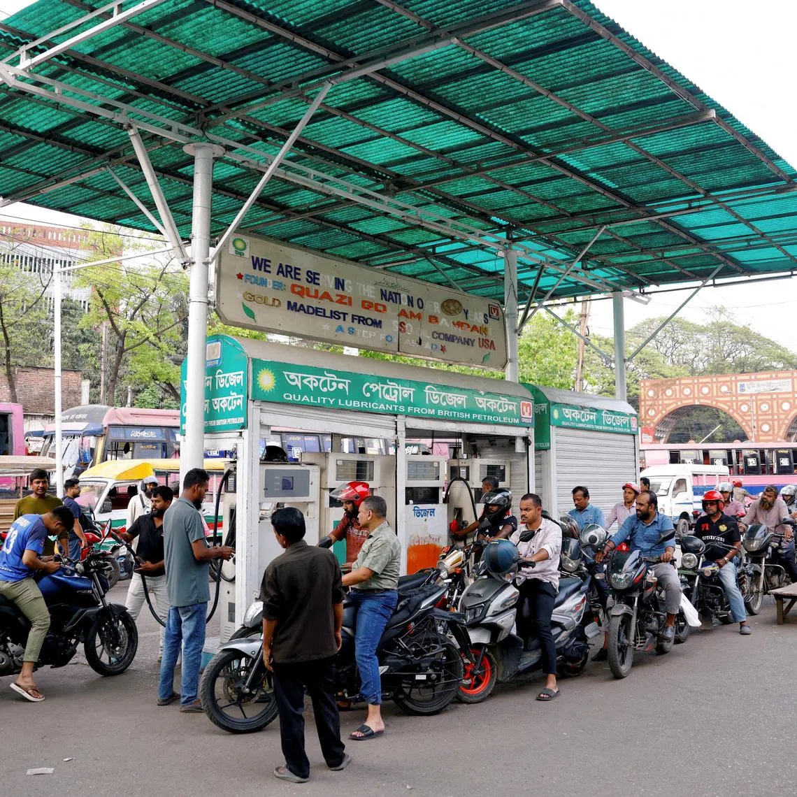 Motorists queueing to refuel their motorcycles at a fuel station in Dhaka, Bangladesh, on March 15. The country's fuel crunch has prompted long queues at petrol stations and power cuts.
