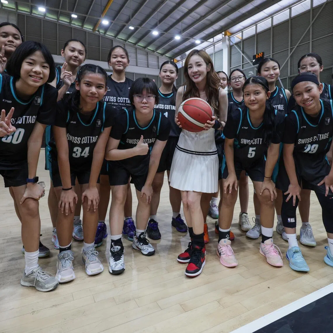 South Korean singer Sandara Park, (centre-in white dress) in a group photo with basketball players from Swiss Cottage Secondary School  during her visit at the Basketball Association of Singapore, on July 17, 2026.