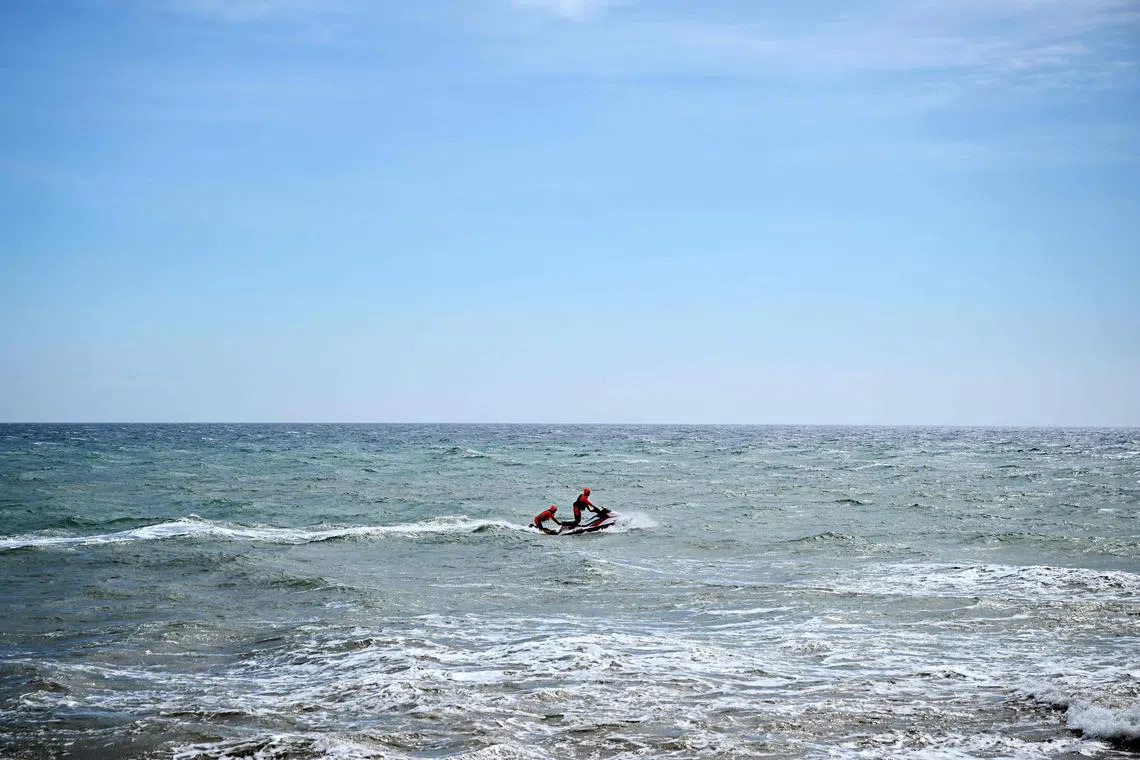 Rescue crew members patrol on a jet-ski on the Mediterranean Sea off a beach coast where at least 72 migrants died on Feb 26, after their boat sank off Italy's southern Calabria region.