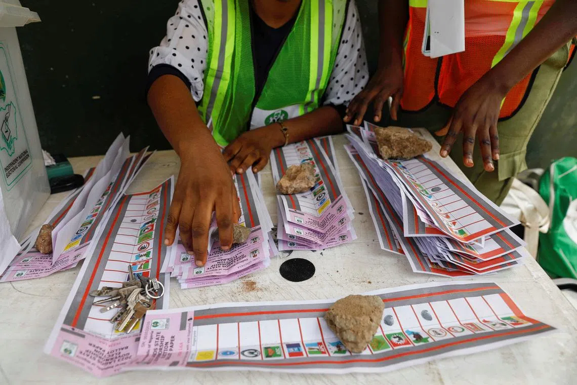 Electoral officials use stones to hold down ballots during the vote counting process of the gubernatorial election at a polling unit in Lagos, Nigeria March 18, 2023. REUTERS/Temilade Adelaja