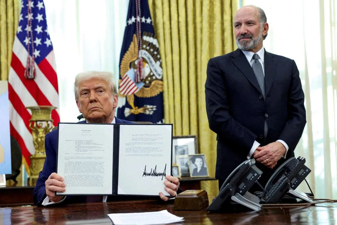 FILE PHOTO: U.S. President Donald Trump holds an executive order about tariffs increase, flanked by U.S. Commerce Secretary Howard Lutnick, in the Oval Office of the White House in Washington, D.C., U.S., February 13, 2025. REUTERS/File Photo