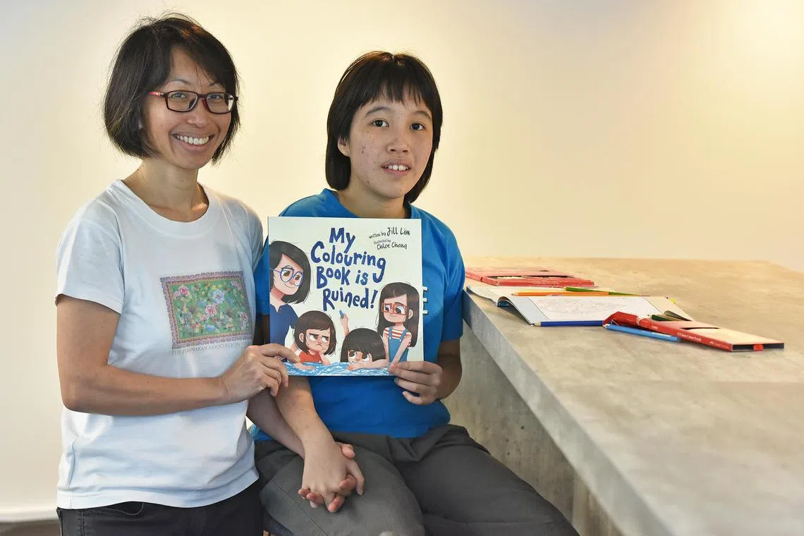 The writer, Jill Lim, and her daughter Kate, who is autistic, with her children’s picture book, My Colouring Book Is Ruined!  