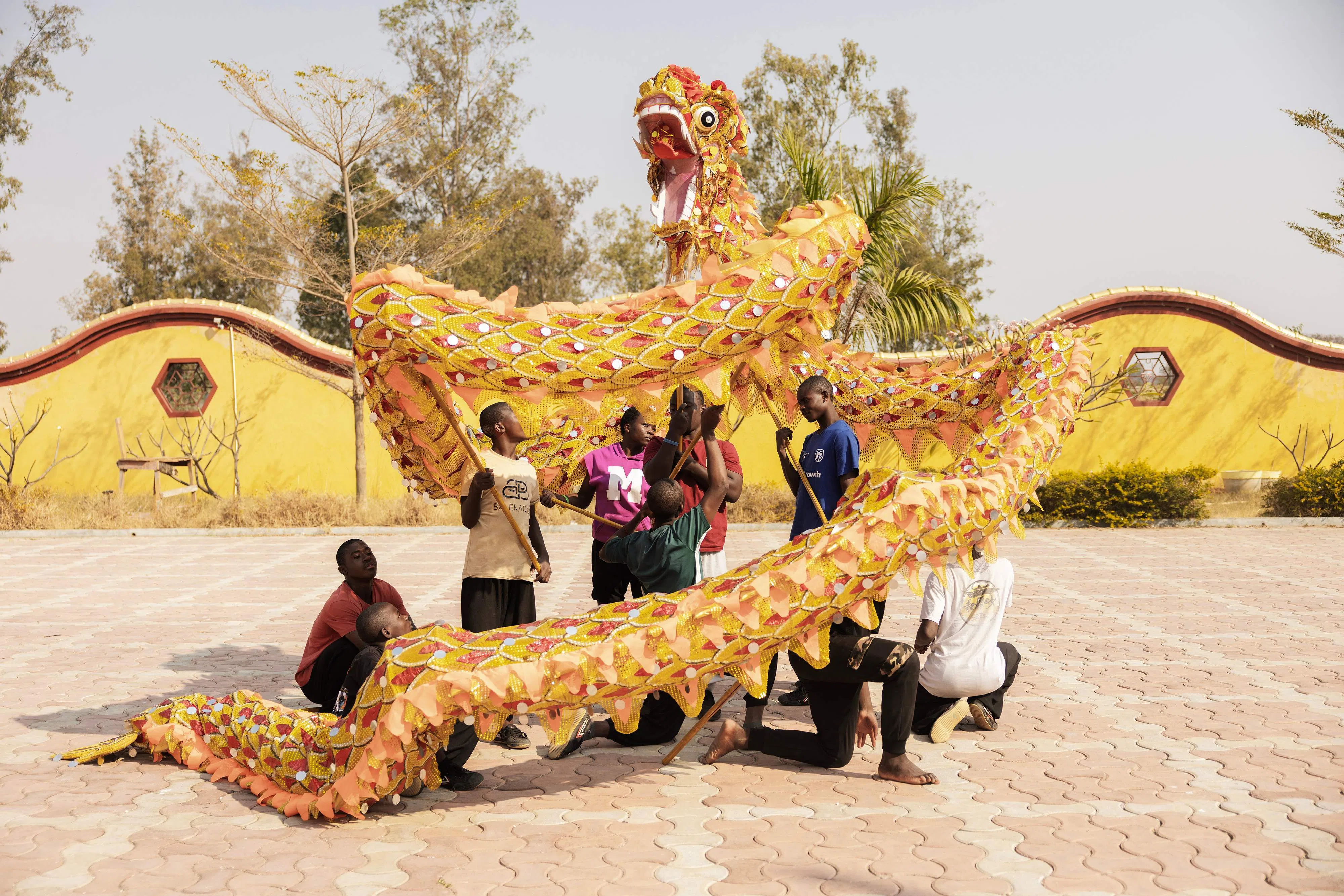 TOPSHOT - Shaolin students train for Dragon Dance at a Shaolin Temple outside Lusaka on August 8, 2026. From a distance, the Shaolin Temple outside Lusaka appears almost like a mirage, a slice of central China dropped into the Zambian landscape. The sprawling complex houses the continent's first Shaolin temple, set on a 20,000-square-metre plot 18 kilometres (11 miles) north of the capital. (Photo by GIANLUIGI GUERCIA / AFP)