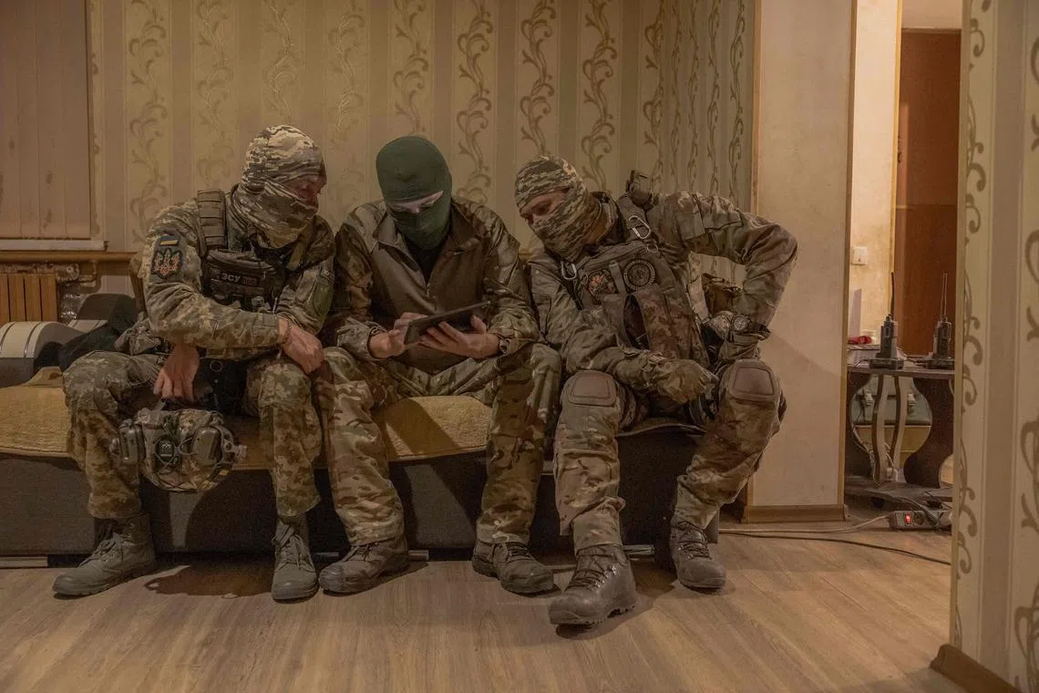 Kuzya (centre) and other members of the Ukrainian sniper team "Ghosts of Bakhmut" prepare for a front-line mission.