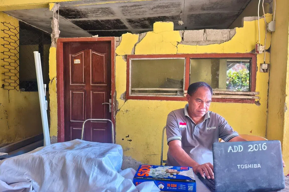 A village official working beneath a damaged building at Rokirole village on Sept 18.