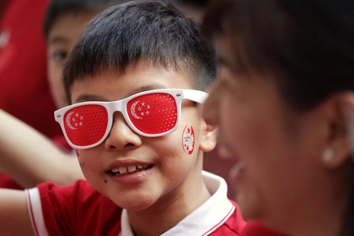 ST20260809_202658800664/Jasel Poh/pixndp2026 Nine-year-old Ethan Tan donning a pair of shades with the cresent and the stars during the National Day Parade at the National Stadium on Aug 9, 2026 ST PHOTO: JASEL POH