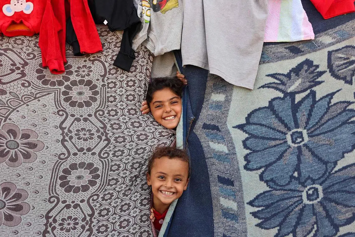 Children playing in a tent at a makeshift camp for Palestinians displaced from northern Gaza, at Gaza City's damaged Yarmouk stadium on Oct 14, 2024, amid the ongoing war between Israel and the Palestinian militant group Hamas.