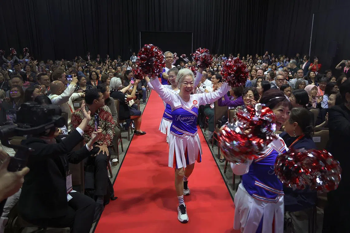 ST20250408_202581200612_smage_Jason Quah Madam Lydia Lee, 77, entering the hall together with the fellow cheerleaders from Singapore's first seniors cheerleading team during the opening act of the World Ageing Festival at Marina Bay Convention Centre on April 8, 2025. ST PHOTO: JASON QUAH