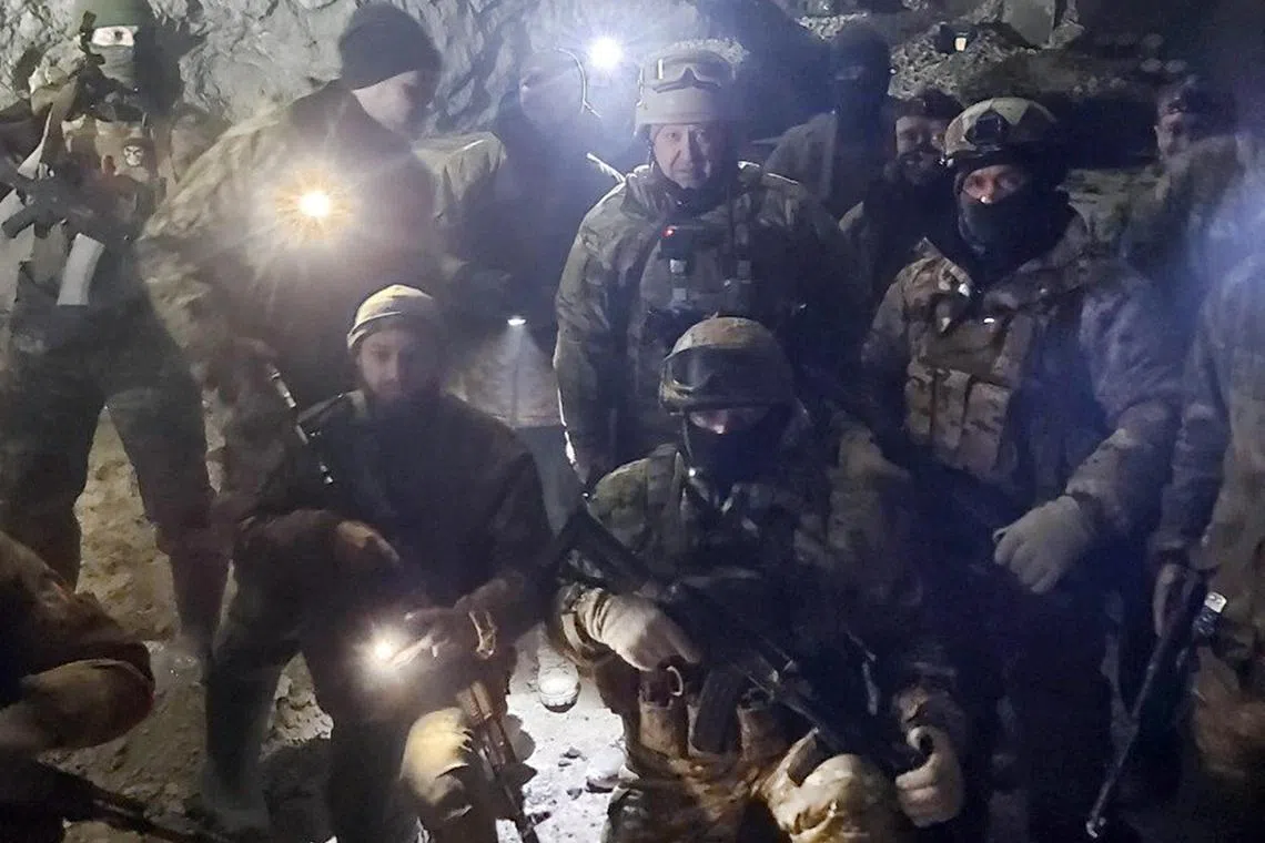 People in military uniform, claimed to be soldiers of Russian mercenary group Wagner and its head Yevgeny Prigozhin, pose for a picture believed to be in a salt mine in Soledar in the Donetsk region, Ukraine, in this handout picture released January 10, 2023. Press service of "Concord"/Handout via REUTERS  ATTENTION EDITORS - THIS IMAGE WAS PROVIDED BY A THIRD PARTY. NO RESALES. NO ARCHIVES. MANDATORY CREDIT. 