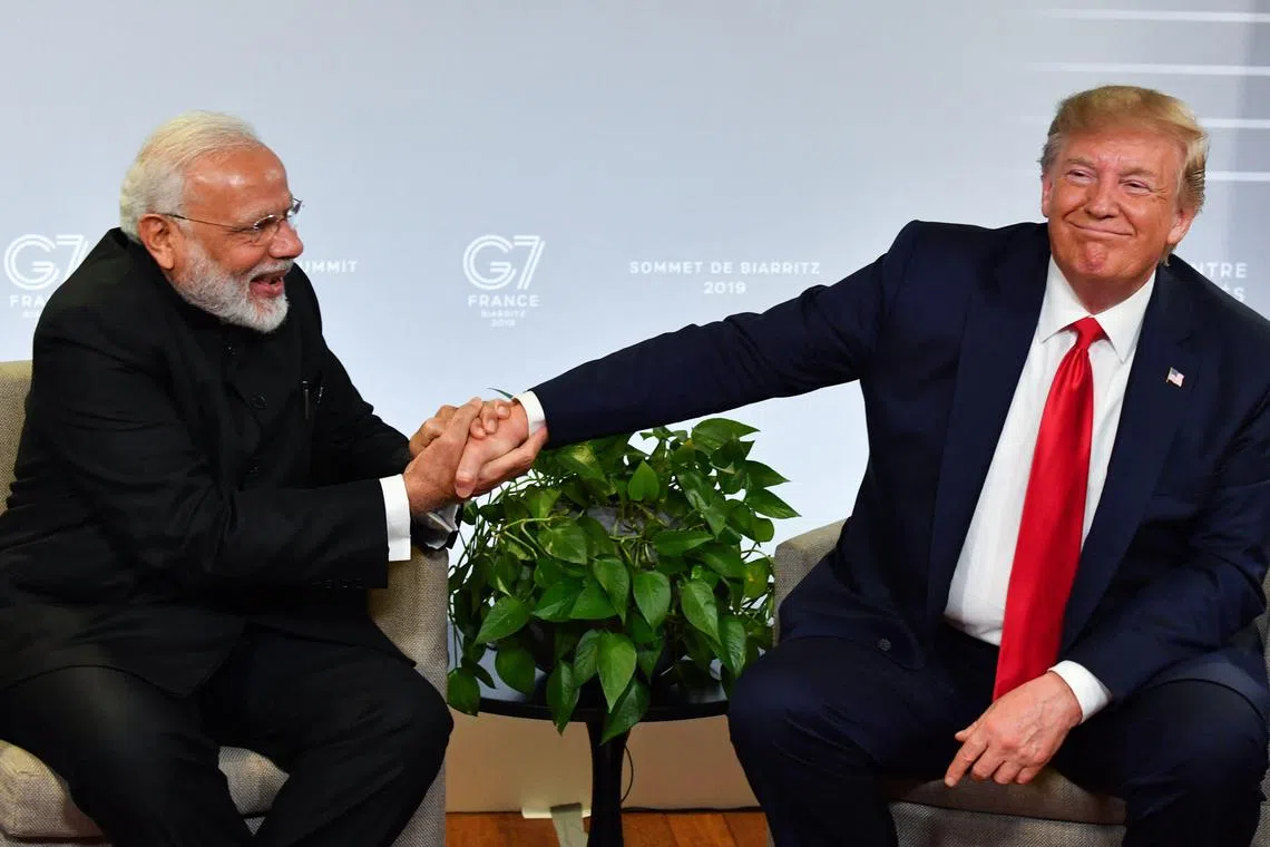 (FILES) (FILES) Indian Prime Minister Narendra Modi (L) and US President Donald Trump shakes hands as they speak during a bilateral meeting in Biarritz, south-west France on August 26, 2019, on the third day of the annual G7 Summit. US President Donald Trump pressed Indian Prime Minister Narendra Modi for "fair" trading ties in a call January 27, 2025, the White House said, as Trump continues to push his hardline trade agenda with world leaders. Trump however also discussed plans for a visit to the White House by Modi, the Hindu nationalist leader with whom he had close ties in his first term as president, a readout of the call said. (Photo by Nicholas Kamm / AFP)