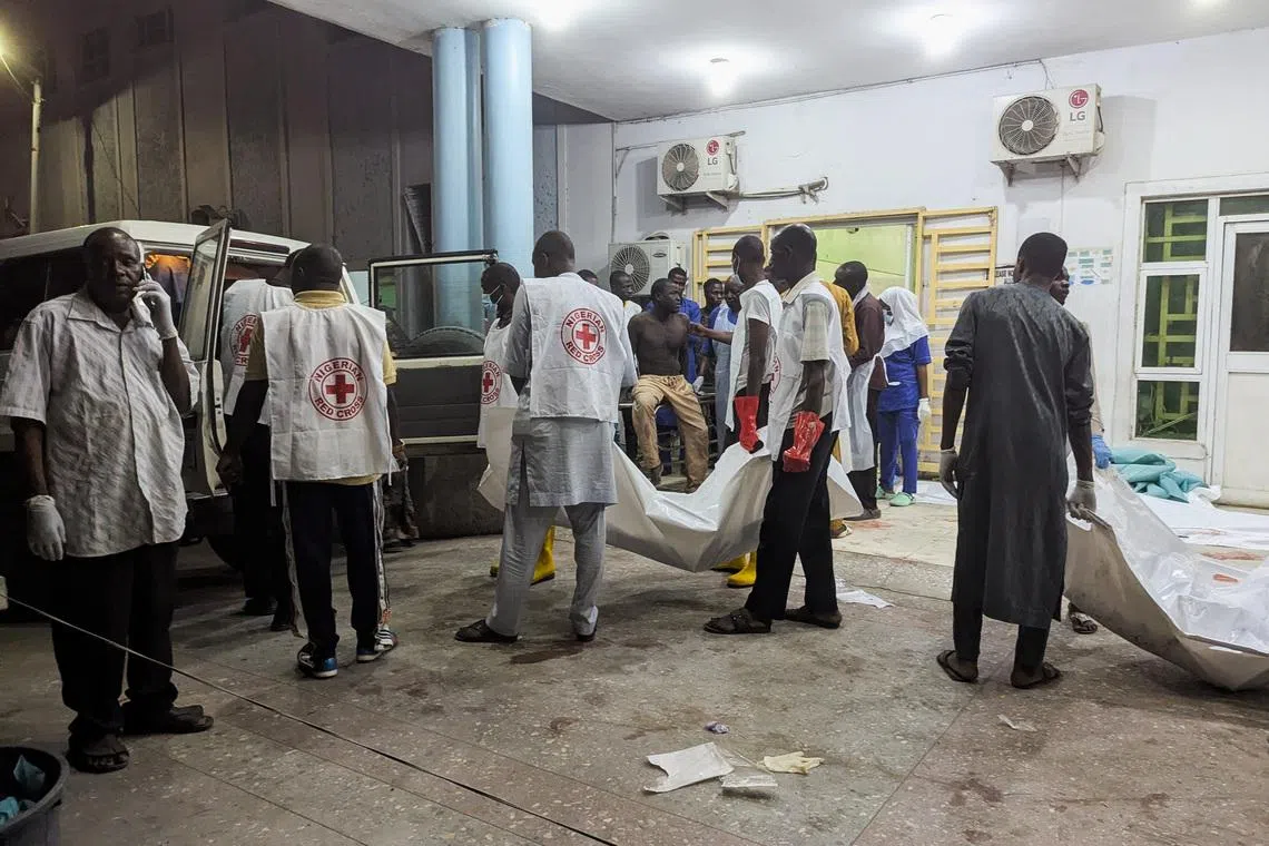 Members of the Nigerian Red Cross carry body bags containing casualties at a Maiduguri hospital following explosions that struck the northeastern city of Maiduguri, Borno State, Nigeria, March 16, 2026. REUTERS/Adewale Kolawole