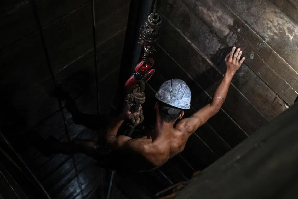 TOPSHOT - A miner works at an illegal copper mine, in Canaa dos Carajas, Para State, Brazil, on April 19, 2023. - Canaa dos Carajas is a small city at the edge of the Brazilian Amazon that has become a boom town in recent years thanks to mining. Canaa is a place of extremes: At one end of the spectrum sits mining giant Vale, which runs one of the world's biggest open-air mines here and has made the city the richest in Brazil in 2020 in GDP per capita. At the other end are an estimated 100 illegal mines where "garimpeiros," illegal miners, make a living digging holes in the earth, living on constant alert in case of a raid. (Photo by Nelson ALMEIDA / AFP)