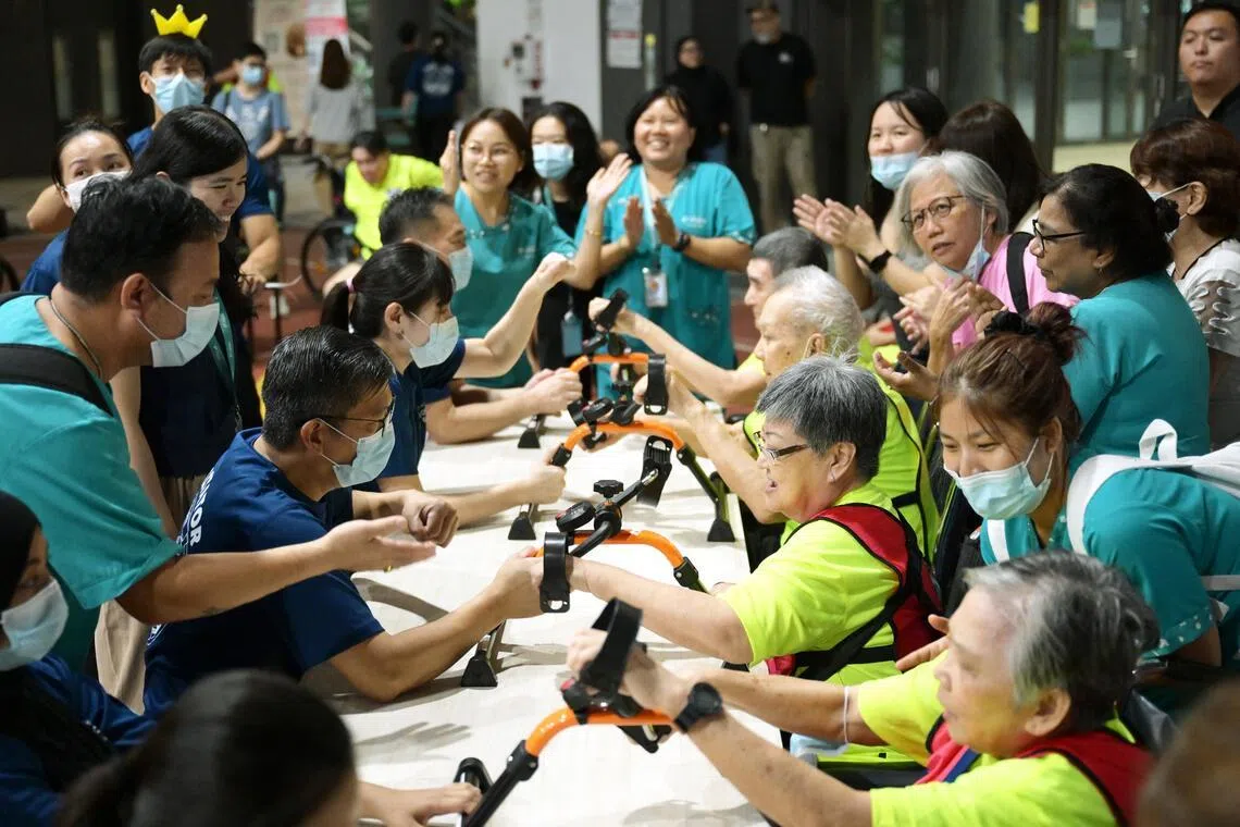 Staff cheer on their residents as they compete in the hand cycling event at the NTUC Health Golden Games in Jurong West on May 18.