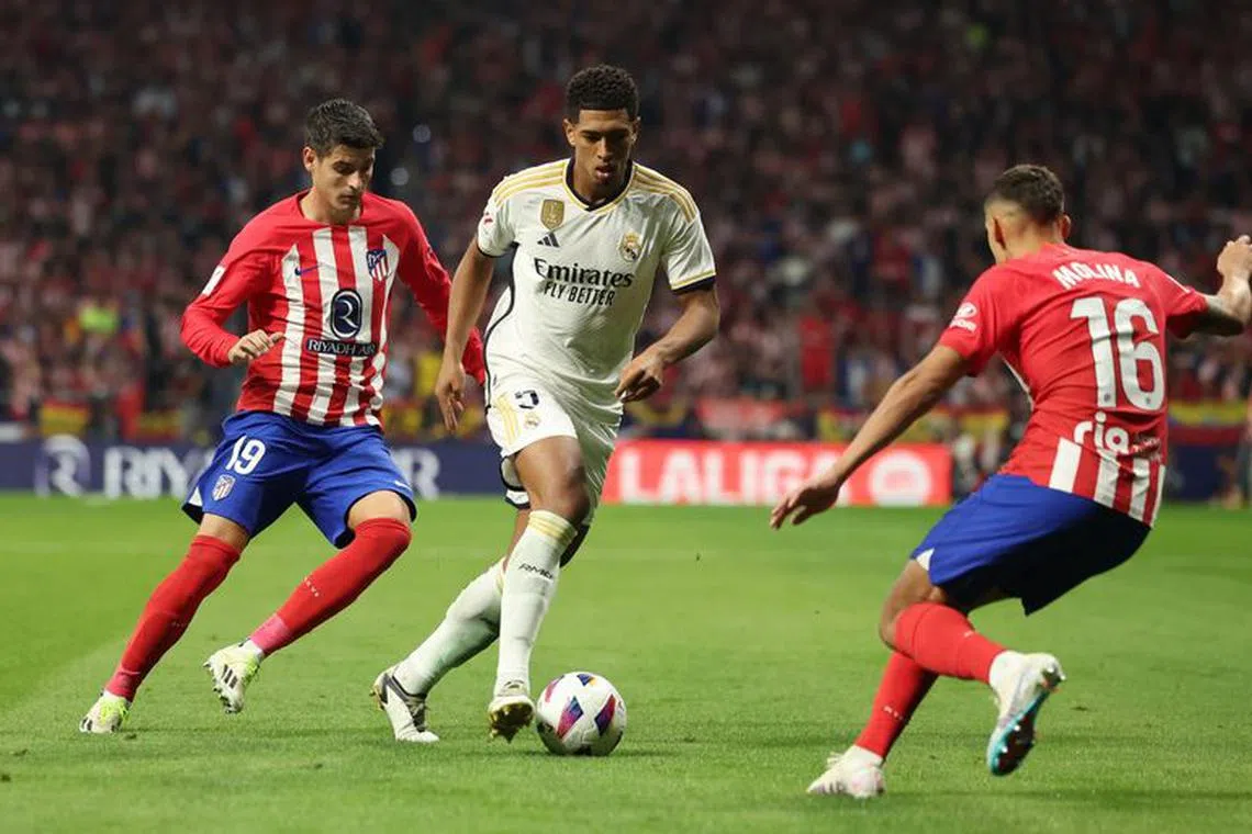 Soccer Football - LaLiga - Atletico Madrid v Real Madrid - Metropolitano, Madrid, Spain - September 24, 2023 Real Madrid's Jude Bellingham in action with Atletico Madrid's Alvaro Morata and Nahuel Molina REUTERS/Isabel Infantes