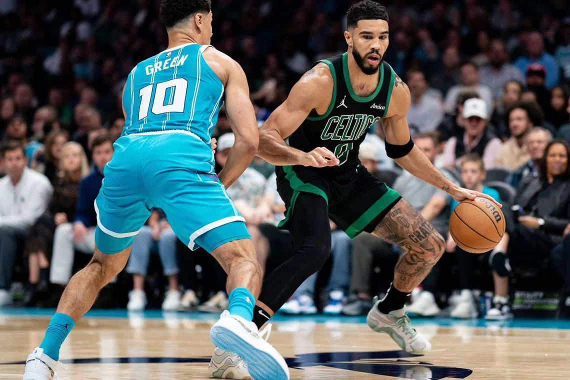 Josh Green of the Charlotte Hornets guards Jayson Tatum of the Boston Celtics in the third quarter during their game at Spectrum Centre.