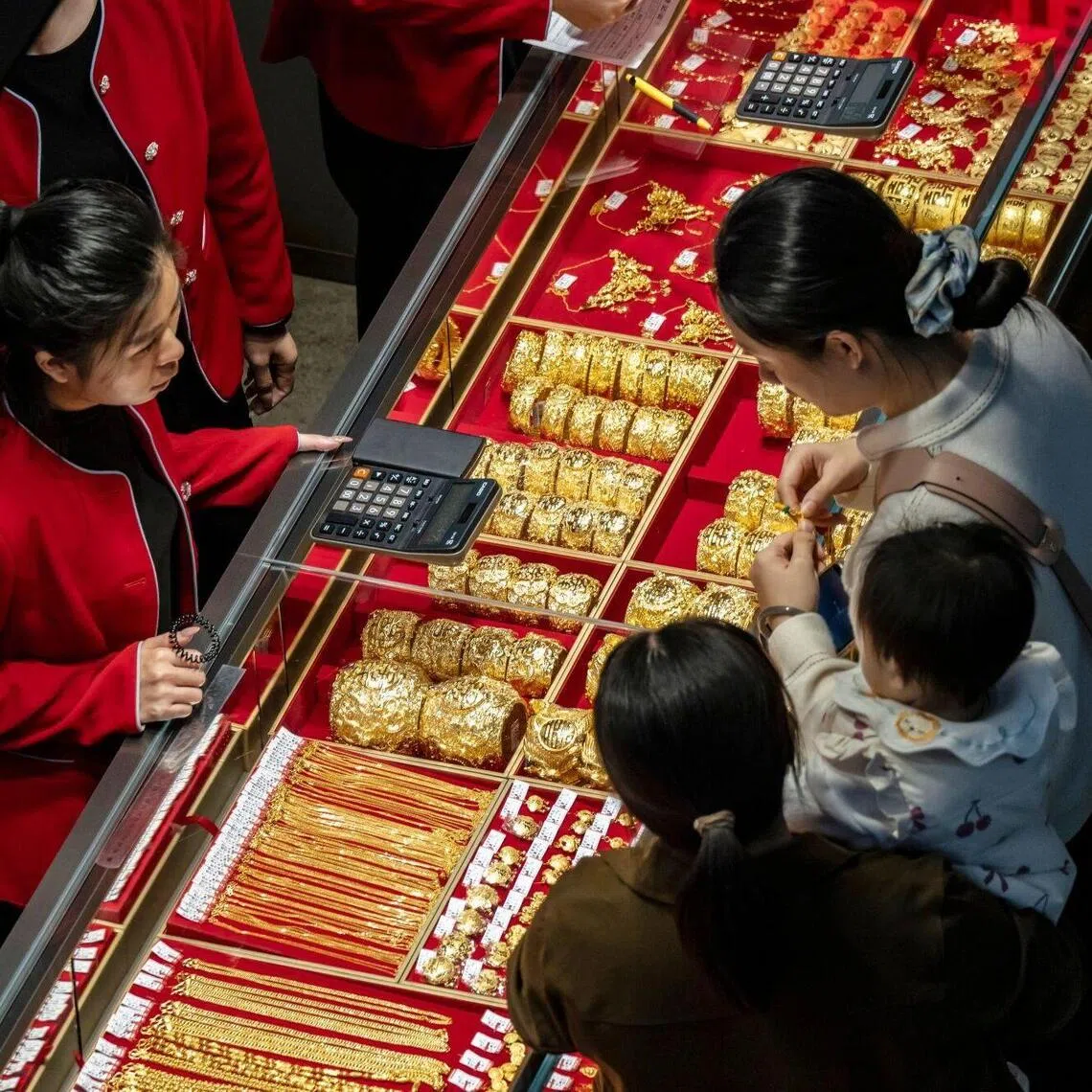 Customers look at gold jewelry at the Jinzhan Jewellery Square in the Shuibei Jewellery market in Shenzhen, China, on Thursday, Nov. 27, 2025. Chinese jewelers and smaller firms in the gold sector look set to be hardest hit by tax changes announced earlier this month that got rid of long-standing incentives for some retailers of the metal. Photographer: Qilai Shen/Bloomberg