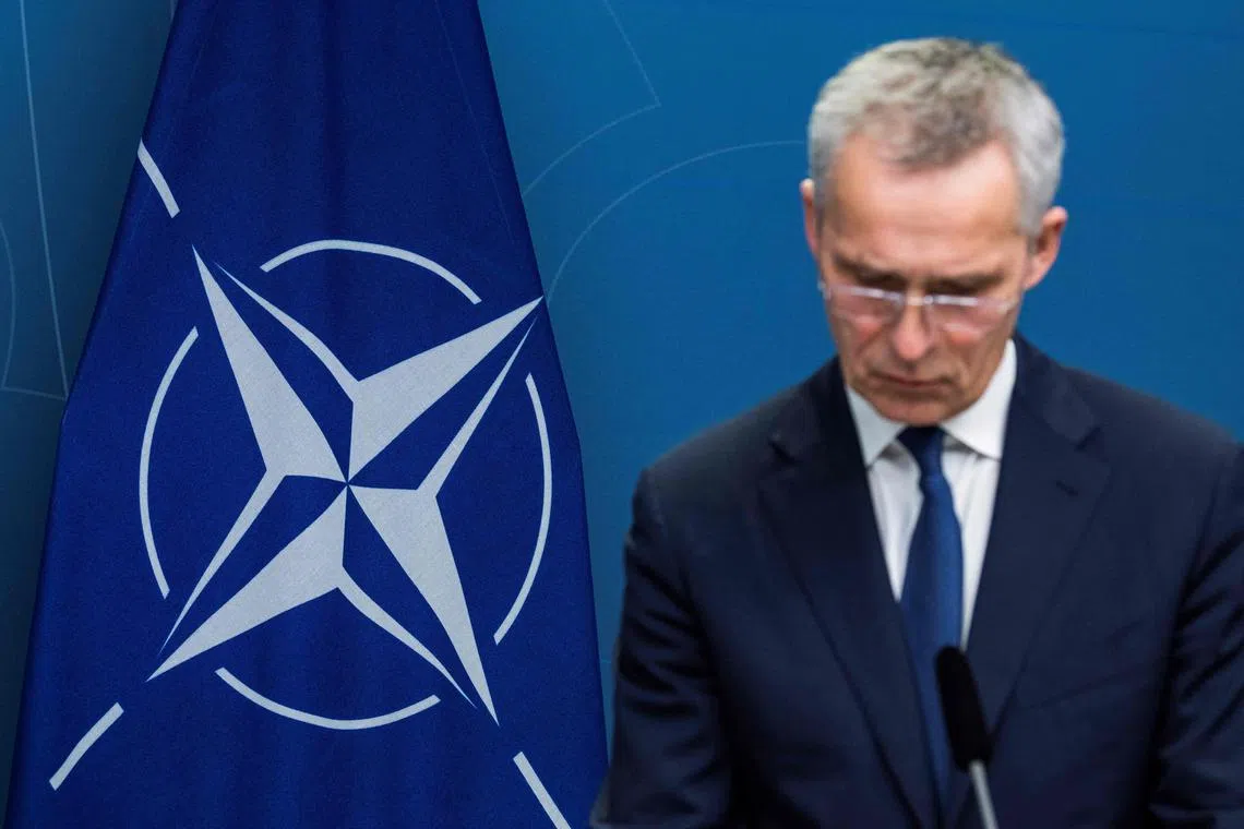Nato's logo is seen on a flag in the background, as Nato Secretary-General Jens Stoltenberg addresses a press conference.