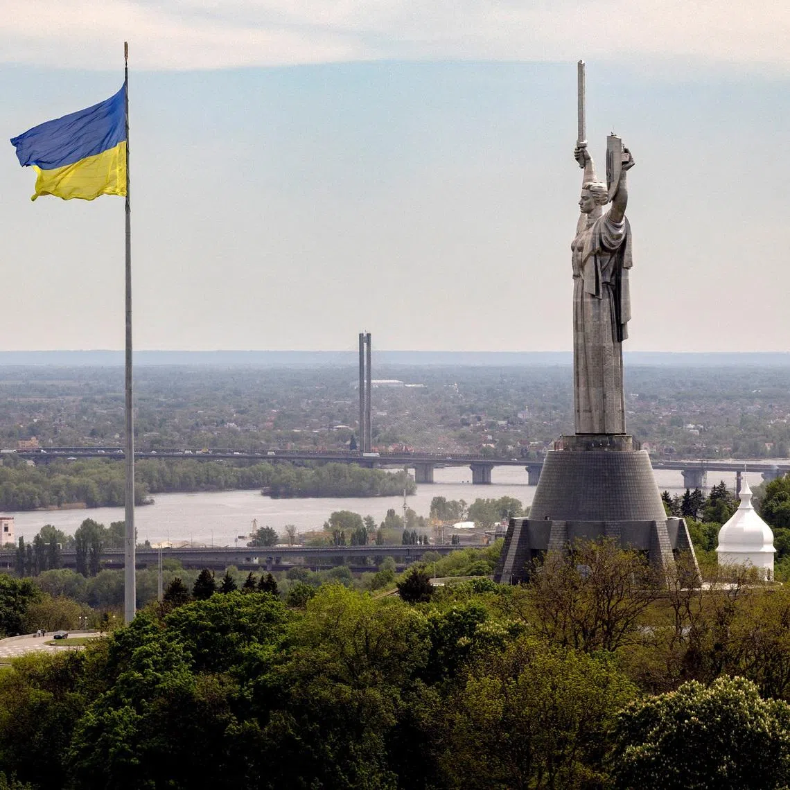 The Ukrainian national flag flies near the Motherland monument at the National Museum of the History of Ukraine in the Second World War, amid Russia’s attack on Ukraine, in Kyiv, Ukraine, May 8, 2026. REUTERS/Thomas Peter