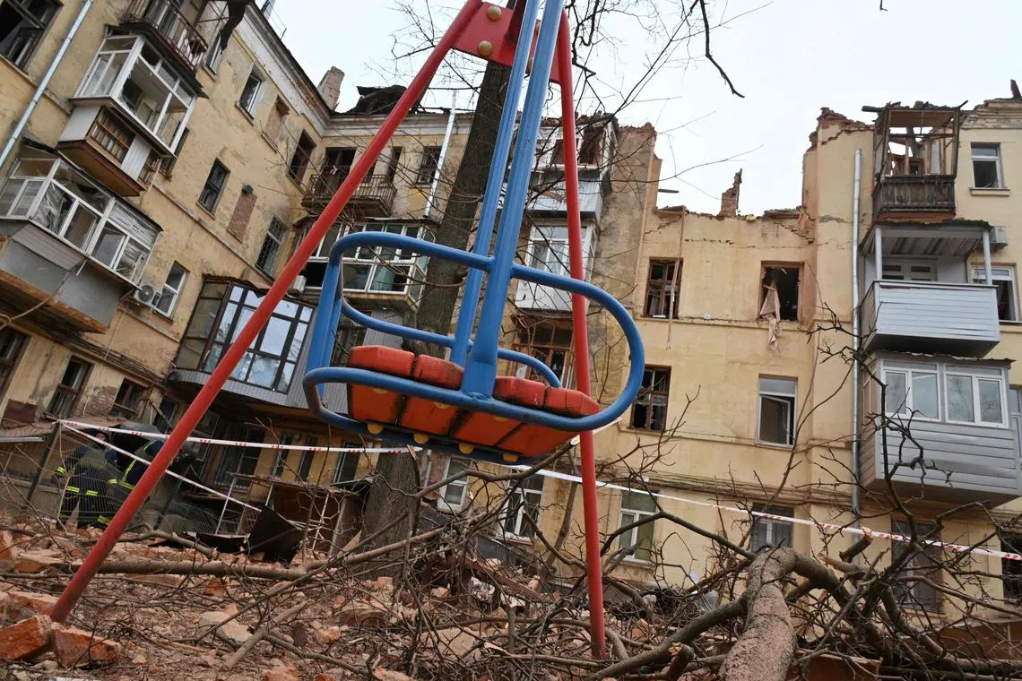 A children's swin is seen outside a residential building, partially destroyed after a missile strike in Kharkiv on January 30, 2023, amid the Russian invasion of Ukraine. (Photo by SERGEY BOBOK / AFP)
