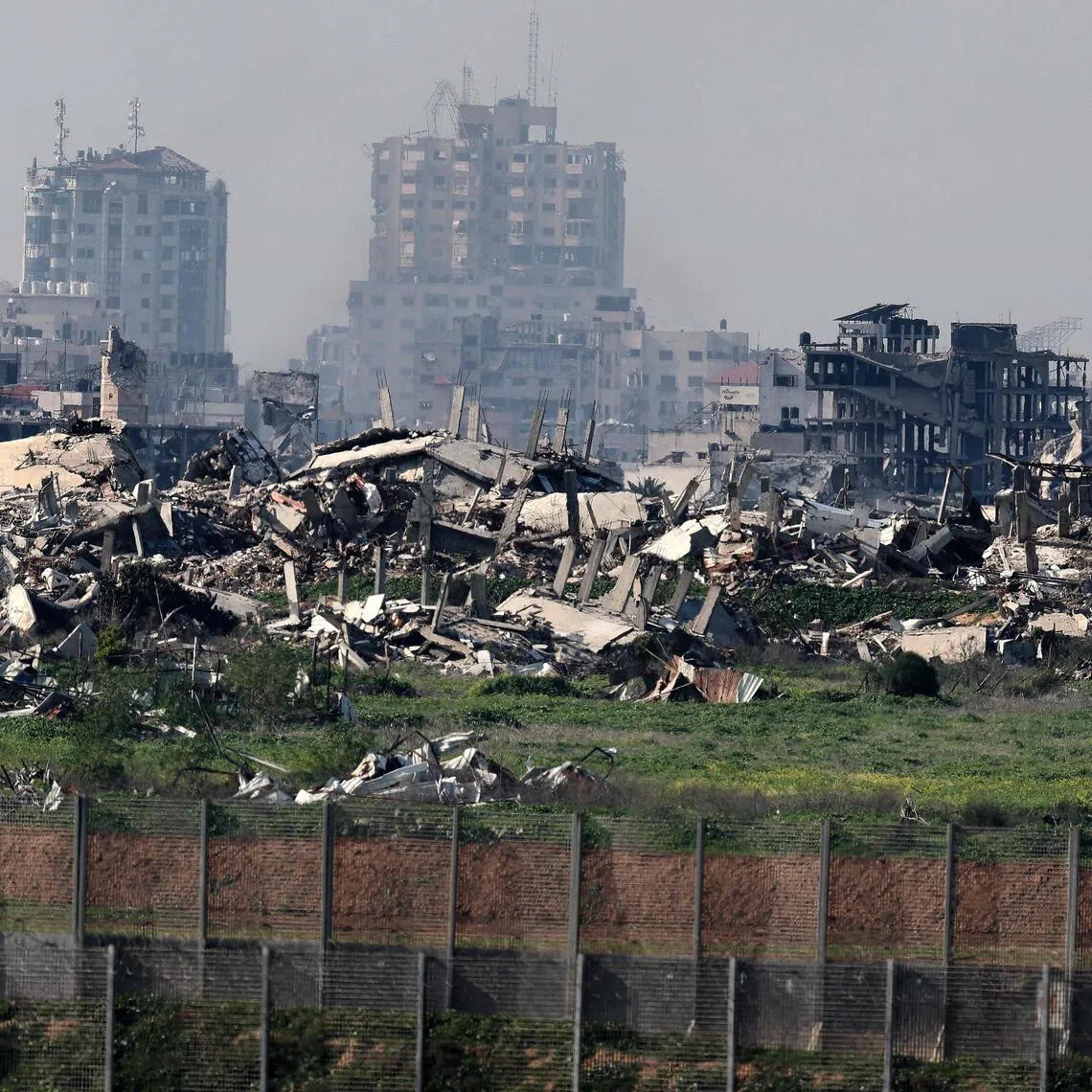 TOPSHOT - This picture taken from a position at Israel's border with the Gaza Strip shows destroyed buildings in the besieged Palestinian territory on February 5, 2026. The October 7, 2023, Hamas attack just across the Israel-Gaza Strip border which resulted in the deaths of 1,221 people on the Israeli side, triggered the Gaza war in which over 71,800 Palestinians have been killed and thousands of buildings destroyed. (Photo by Jack GUEZ / AFP)