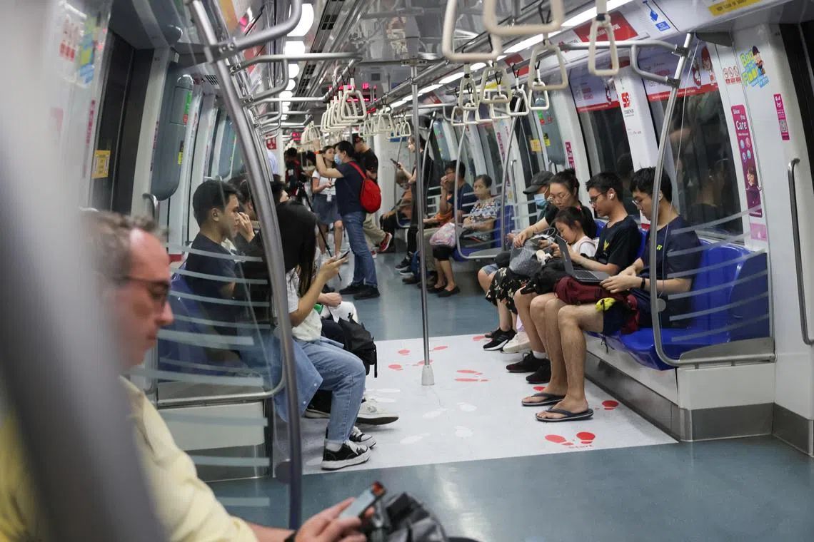 Commuters travelling onboard an NDP-themed train on July 8, 2024.