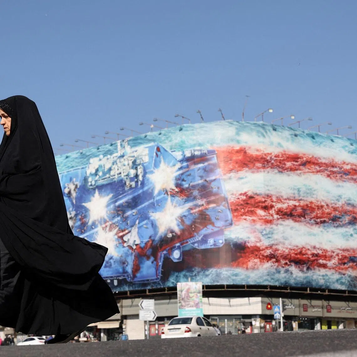 An Iranian woman walks past an anti-US billboard in Tehran, Iran, on Feb 26, 2026.