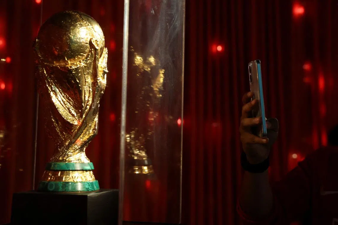 A man takes a photo of a replica of the World Cup trophy as he visits the \"Epic Album\" exhibition, the biggest football exhibition in Latin America that contains relics of legends such as Ronaldo, Cruyff, Pelé and a collection of Mexican national team t-shirts, as the 2026 FIFA World Cup approaches in Mexico at the Museo Yancuic, in Mexico City, Mexico May 15, 2026. REUTERS/Raquel Cunha