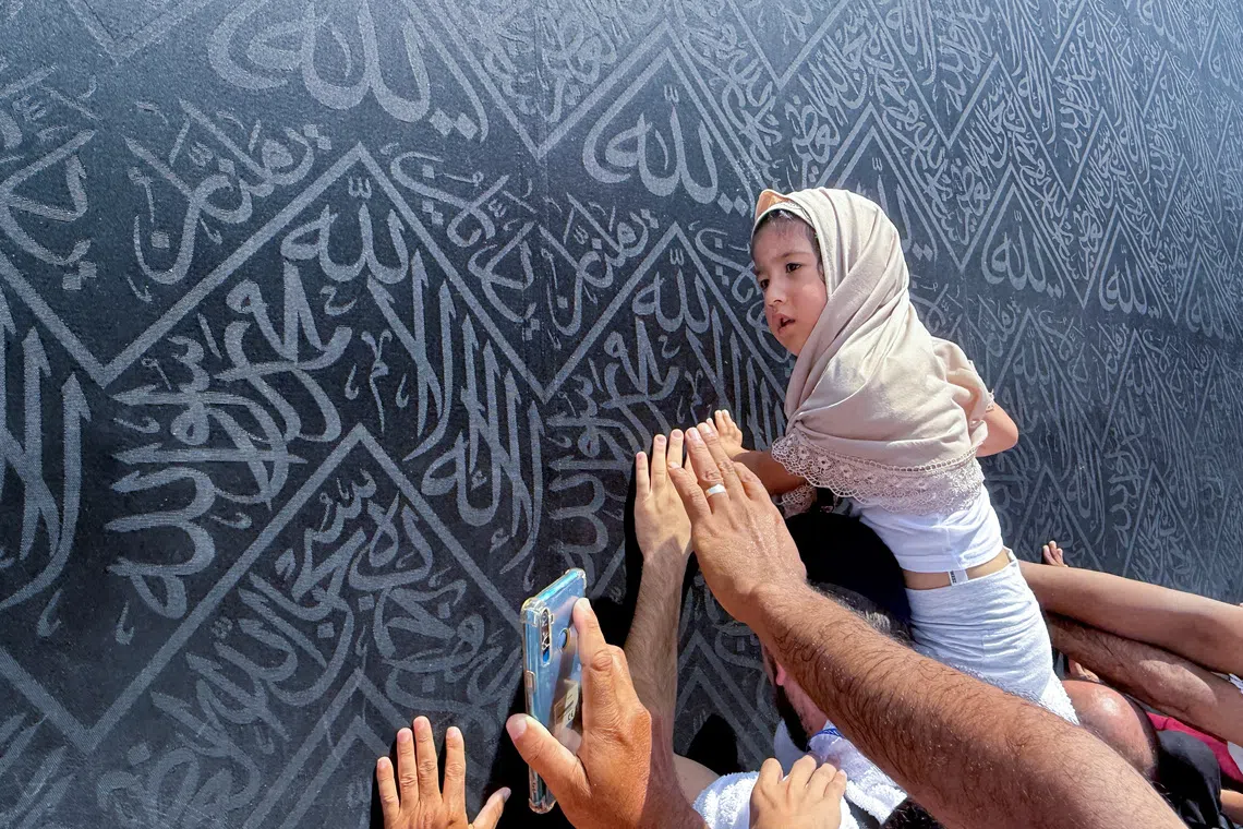 A child touches the Kabaa as Muslim pilgrims perform Umrah at the Grand Mosque in the holy city of Mecca, on Oct 13.