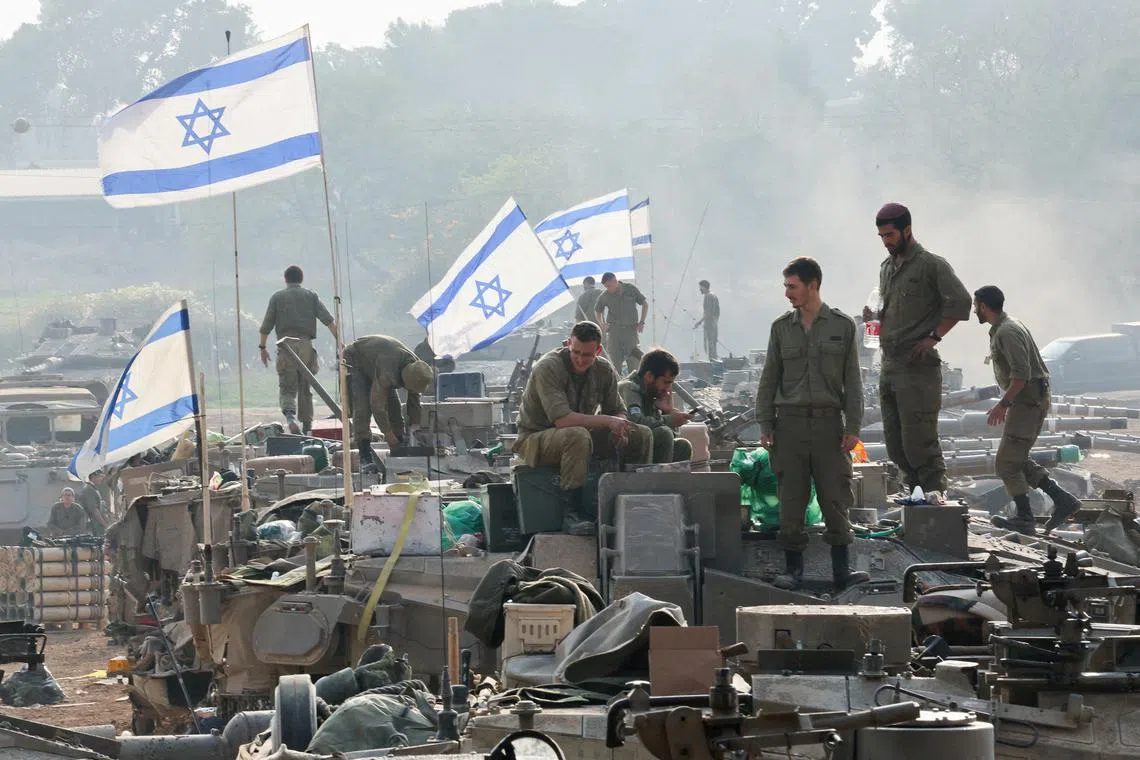 FILE PHOTO: Israeli soldiers stand on tanks, amid the ongoing conflict between Israel and the Palestinian Islamist group Hamas, near the Israel-Gaza border, in southern Israel, January 1, 2024. REUTERS/Violeta Santos Moura/File Photo