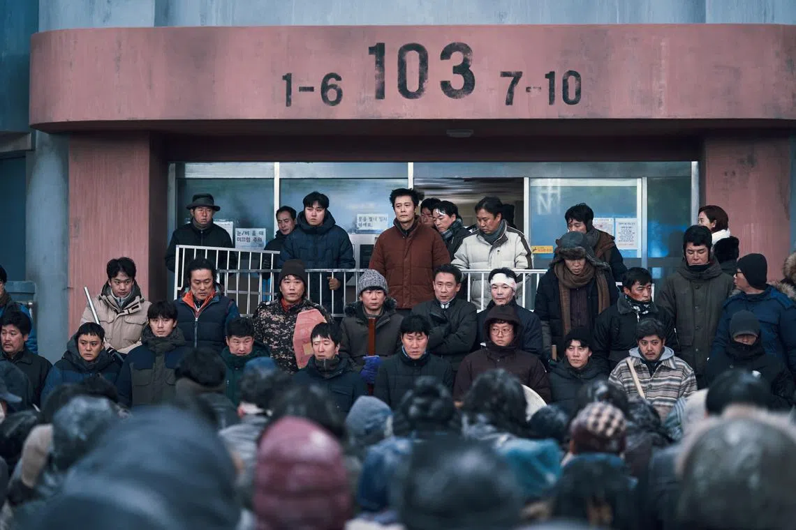 In Concrete Utopia, Lee Byung-hun (centre in brown) leads a group of apartment residents to survival after an apocalyptic earthquake strikes South Korea.