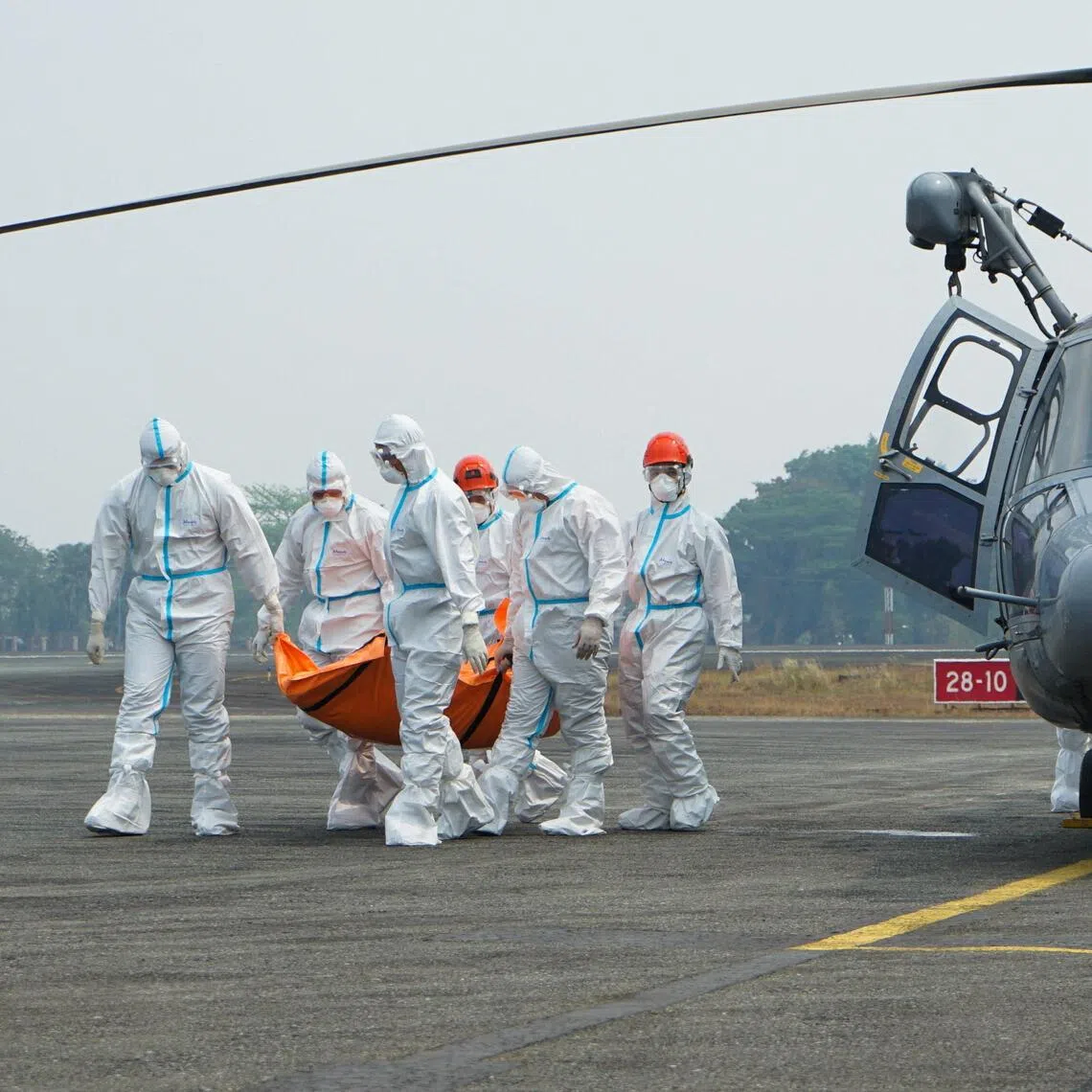 Rescuers carrying a body recovered from the Virgo Transport 8 ferry, which capsized on Sept 13, after arriving at Sjamsudin Noor air base in Banjarbaru, Indonesia, on Sept 28.
