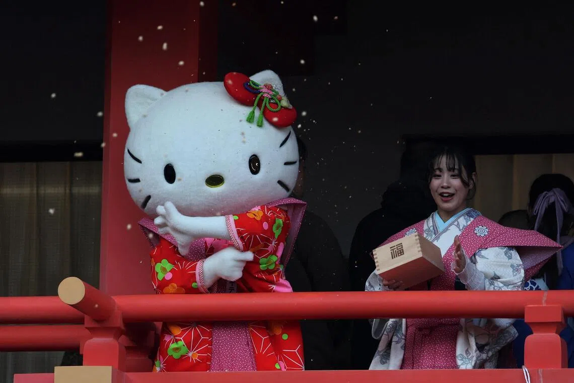 A participant dressed as Hello Kitty throws beans during the annual Setsubun ceremony to celebrate the upcoming arrival of spring.