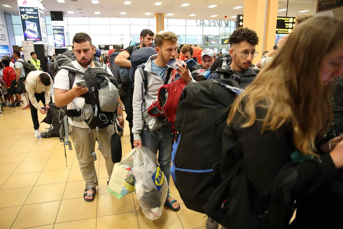 Young Israelis queueing to board a flight to Tel Aviv at the Jorge Chavez International Airport in Lima, Peru, on Oct 10, following the drafting of 300,000 reservists. 