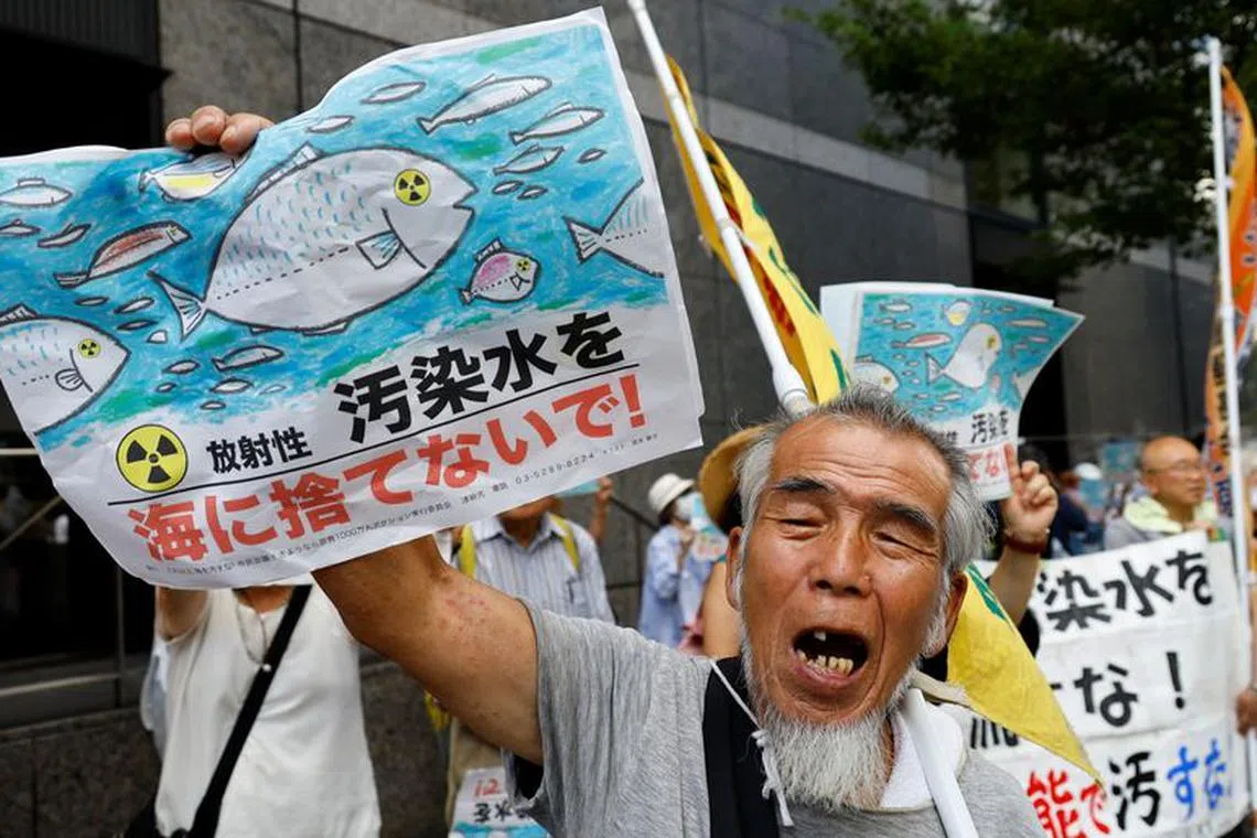 A protester holds a placard that reads \"No radiation contaminated water into the sea\" during a rally against Japan's plan to discharge treated radioactive water from the tsunami-crippled Fukushima Daiichi nuclear plant into the ocean, in front of the headquarters of Tokyo Electric Power Company (TEPCO), the operator of the nuclear plant in Tokyo, Japan, August 24, 2023. REUTERS/Kim Kyung-Hoon