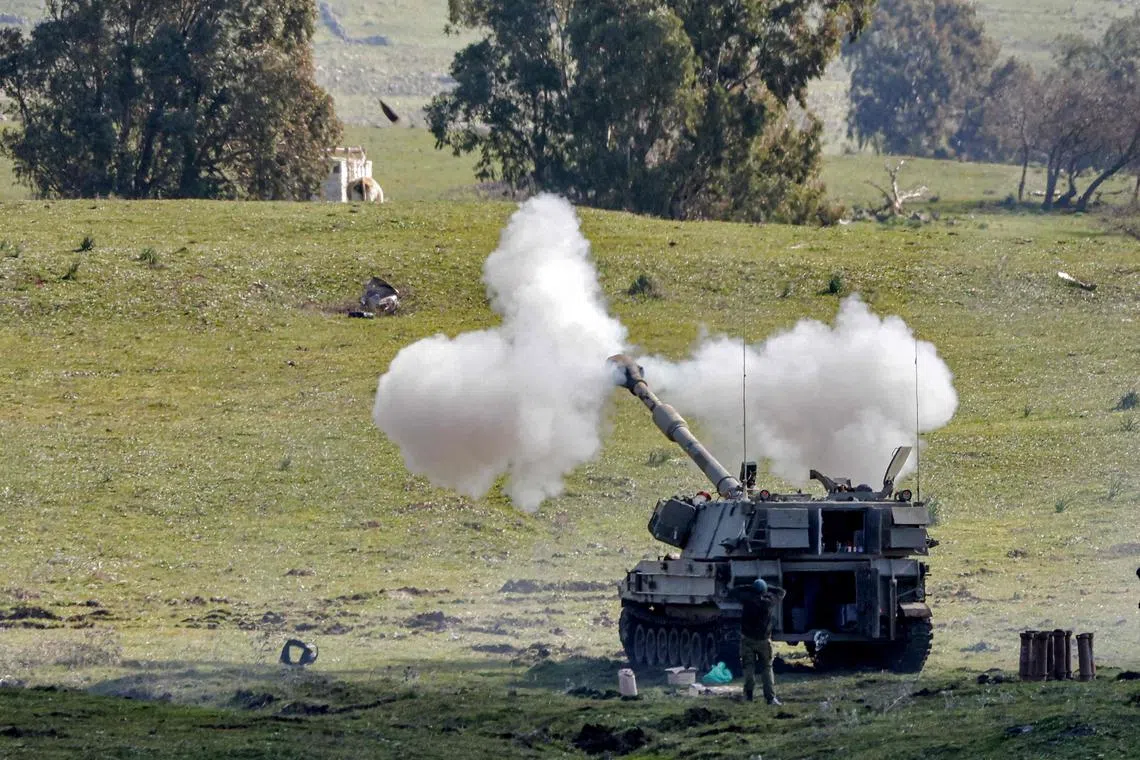 Israeli army M109 155mm self-propelled artillery howitzers fire rounds during a military exercise near the town of Katzrin, in the Israeli-annexed Golan Heights on the border with Syria, on February 15, 2023. (Photo by JALAA MAREY / AFP)