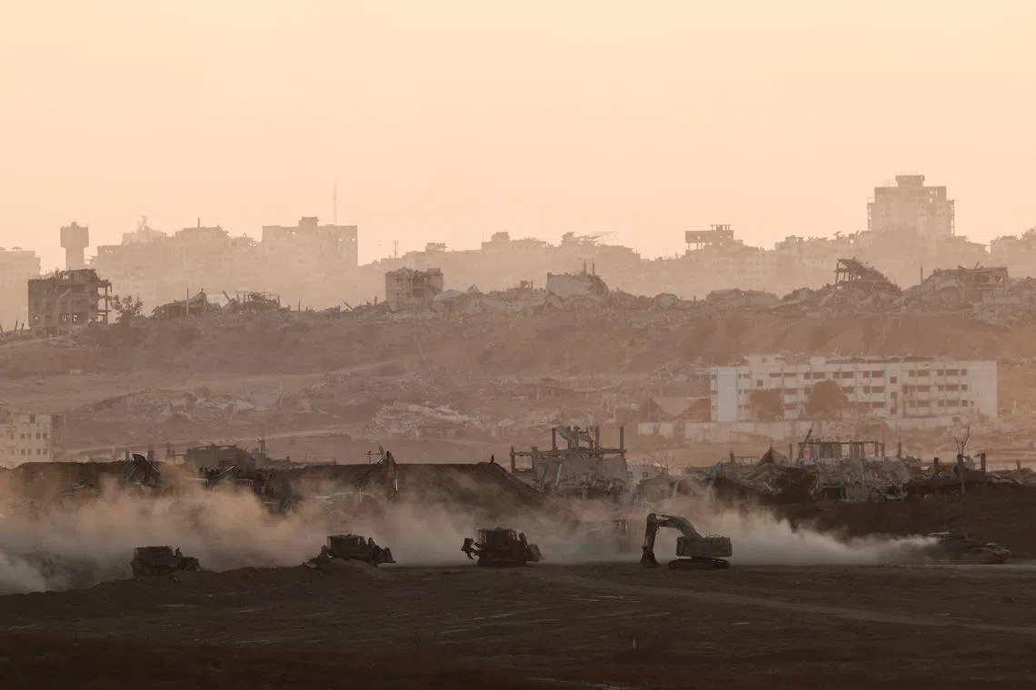 FILE PHOTO: A tank drives near Israeli heavy machinery, as seen from the Israeli side of the Israel-Gaza border, July 13, 2025. REUTERS/Amir Cohen/File photo