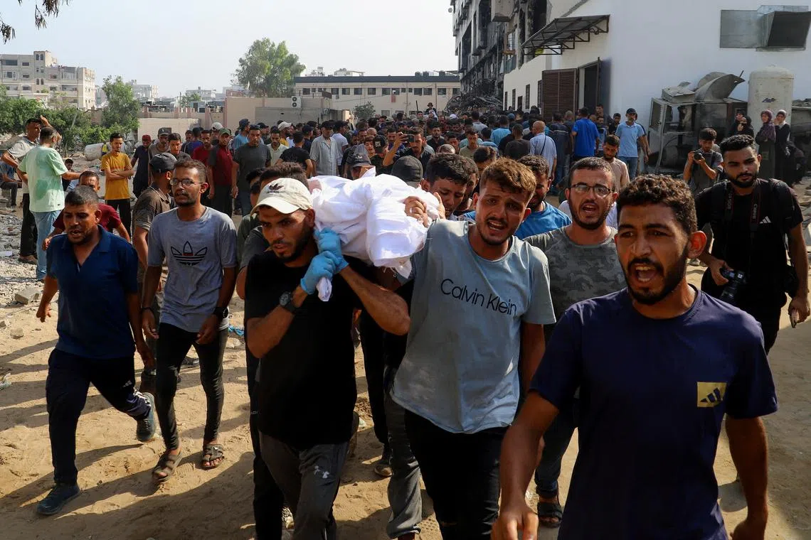 Mourners carry a body during the funeral of Palestinians killed in Israeli fire while seeking aid on Wednesday, according to medics, in Gaza City, August 14, 2025. REUTERS/Ebrahim Hajjaj