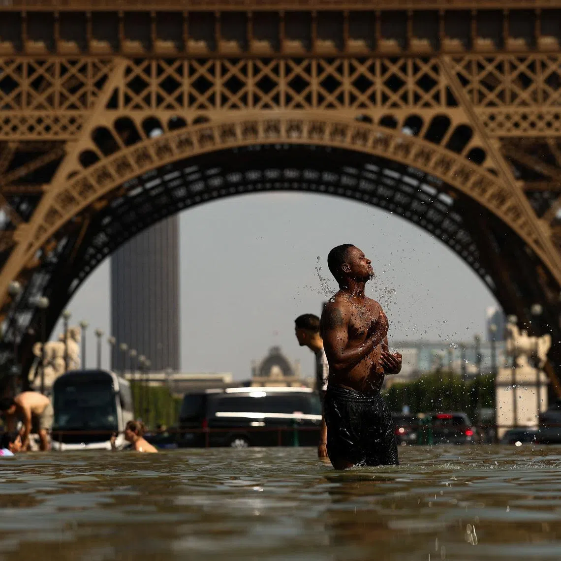 People cool off in the Trocadero Fountain near to the Eiffel Tower as temperatures rise during a heatwave affecting a large part of the country, in Paris, France, June 24, 2026. REUTERS/Gonzalo Fuentes