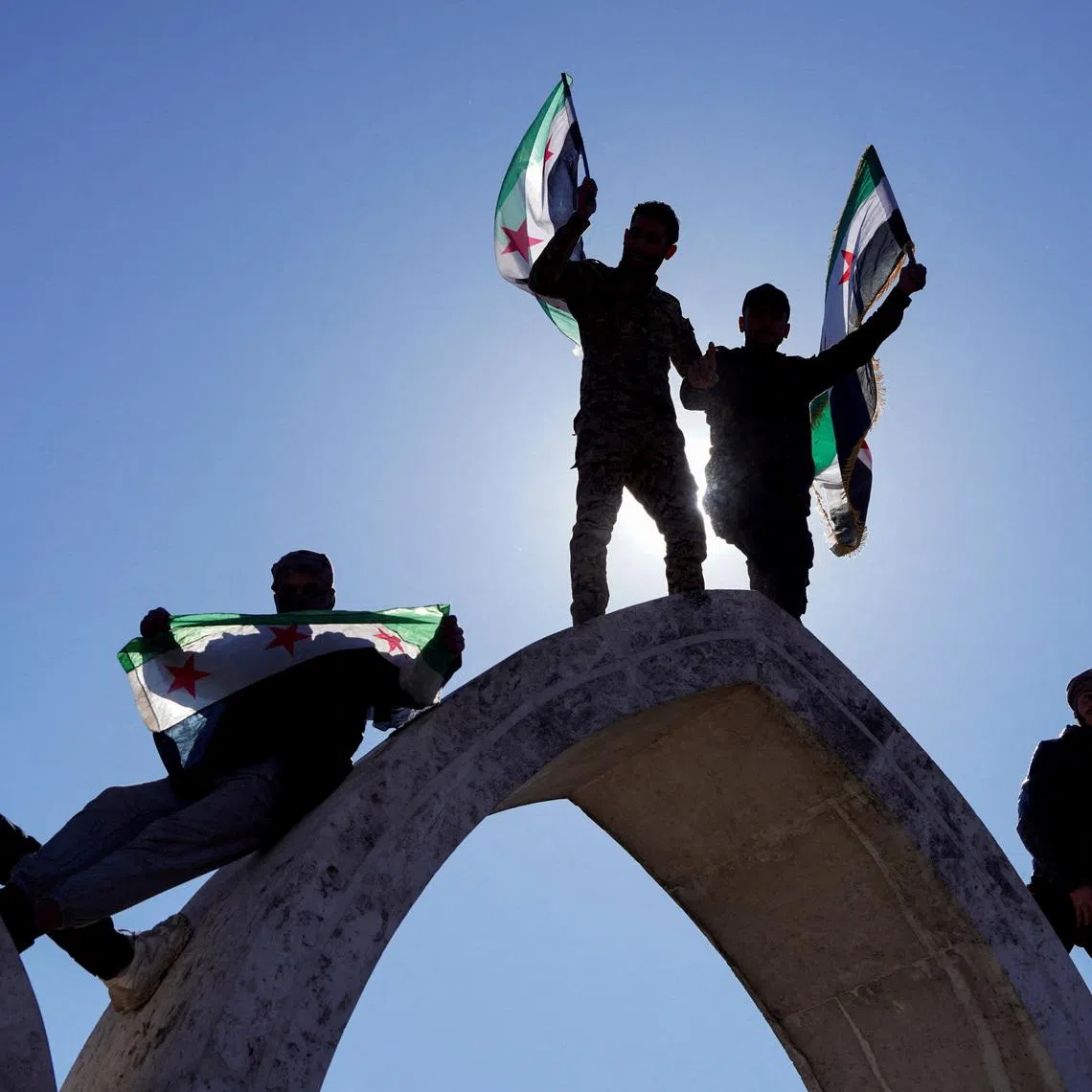 People hold flags as they celebrate, after Syria and the main Kurdish fighting force SDF struck a wide-ranging deal to bring Kurdish civilian and military authorities under central government control on Sunday, ending days of fighting in which Syrian troops captured territory including key oil fields, in Raqqa, Syria January 19, 2026. REUTERS/Karam al-Masri