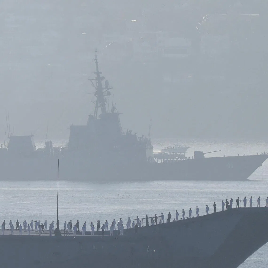 Australian warship HMAS Canberra sails near HMAS Brisbane, a Hobart Class guided missile destroyer (DDG), on Sydney Harbour.