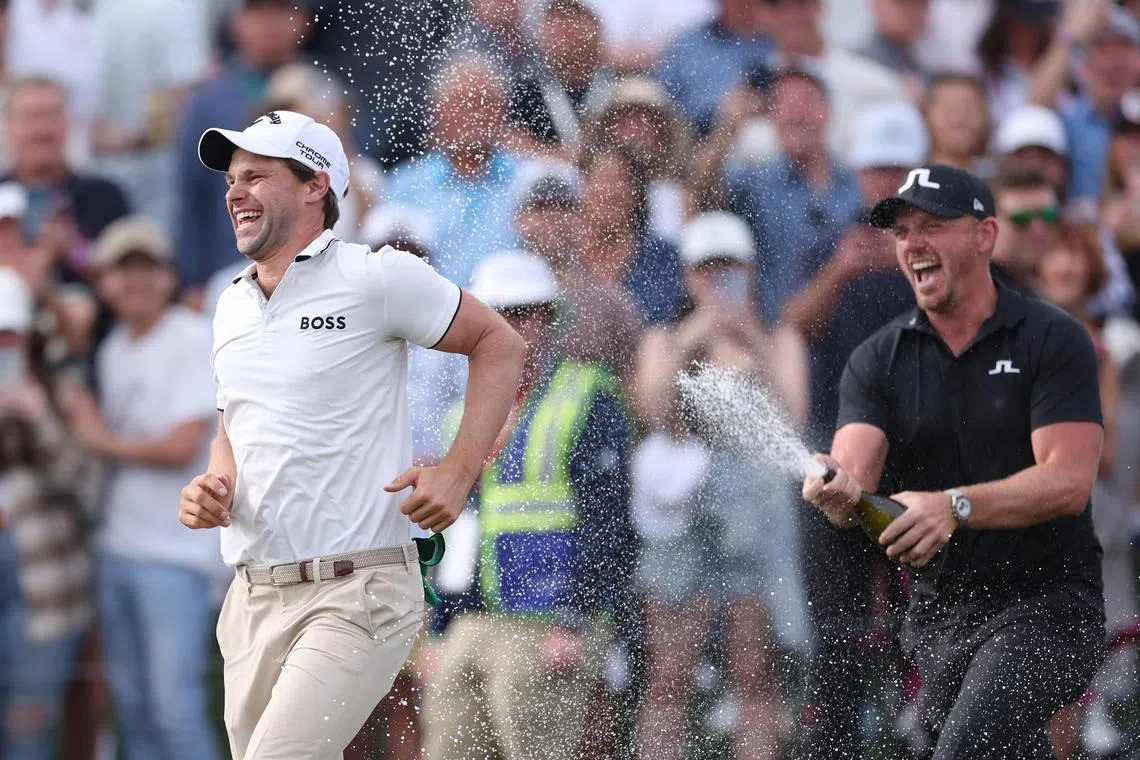 Thomas Detry of Belgium being sprayed with champagne by Matt Wallace of England after winning the Phoenix Open 2025 at TPC Scottsdale on Feb 9 in Scottsdale, Arizona.