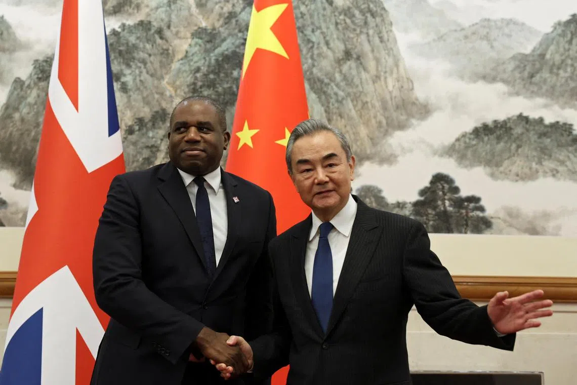 Britain's Foreign Secretary David Lammy (left) and Chinese Foreign Minister Wang Yi (right) shake hands before their meeting at the Diaoyutai State Guesthouse in Beijing, China.
