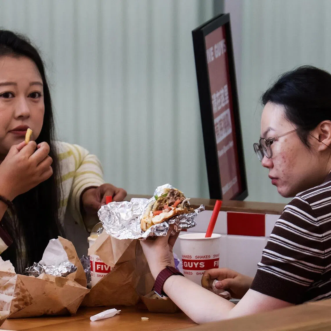 Diners at a Five Guys fast-food restaurant after the US burger chain opened its first two locations in Beijing earlier in August.