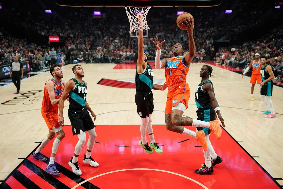 Jalen Williams of the Oklahoma City Thunder driving to the basket against Shaedon Sharpe of the Portland Trail Blazers during the first half of the Thunder's 123-115 NBA win at Moda Center on November 30, 2025, in Portland, Oregon.