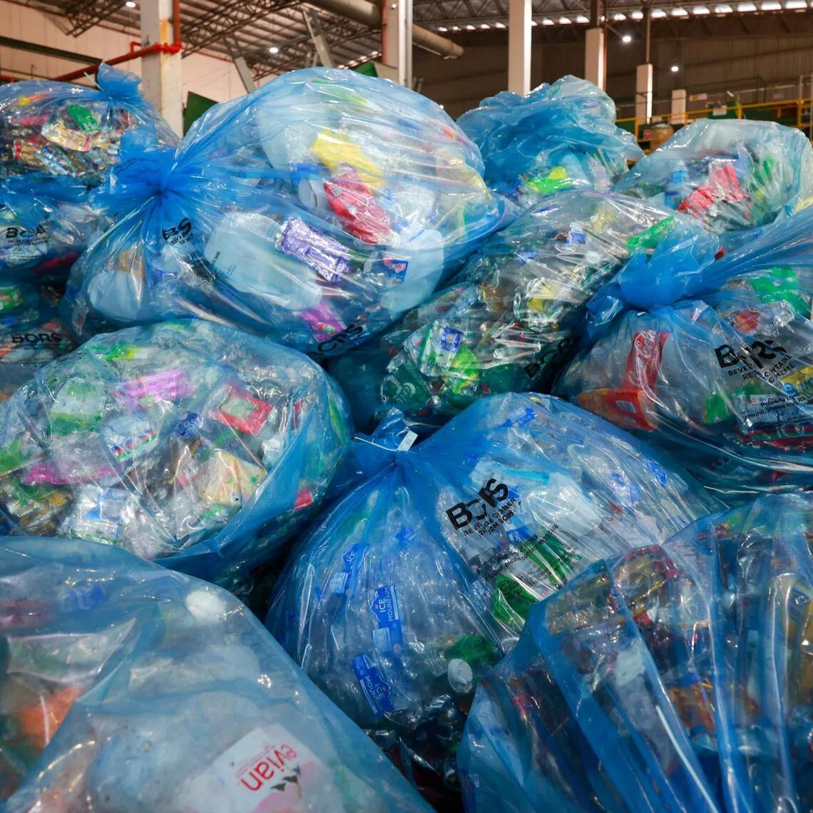 Bags of flattened cans and plastic bottles are piled at the new Counting and Sorting Facility in Tuas.